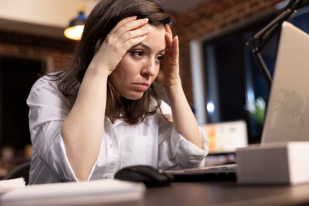 Profissional trabalhando no computador com expressão de preocupação